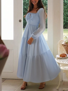 Detail of light blue long sleeve dress featuring square neckline and tiered skirt design