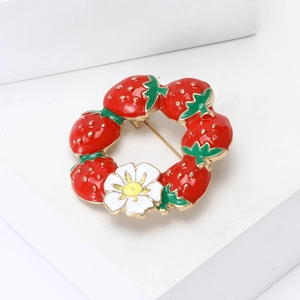 Elegant strawberry wreath brooch with enamel red berries and white daisy on a gold setting