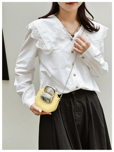 Close-up of yellow PU leather mini bag with circular metal handle and chain strap