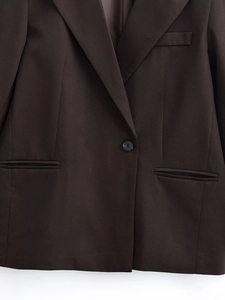 Detailansicht des dunkelbraunen Blazers mit Revers und feiner Stoffstruktur