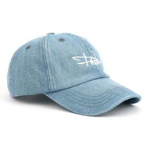 Detail of light blue denim baseball cap with white script embroidery and curved brim