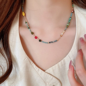 Close-up of colorful natural stone beaded necklace worn by a model with casual style