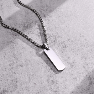 Detailed view of rectangular stainless steel dog tag pendant with a silver box chain