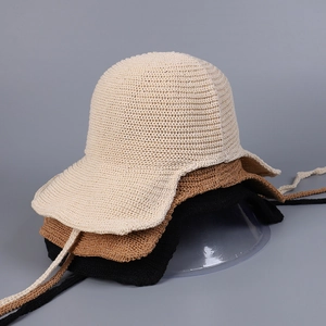 Close-up of lightweight knitted sun hats in beige, brown, and black with strap details