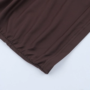 Detailed close-up of brown lace dress showing silk-smooth fabric and precision stitching