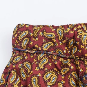 Close-up of paisley print pattern on smooth satin fabric with sharp stitching details