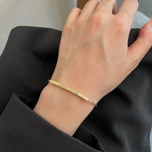 Elegant gold titanium steel bracelet with Lover Dream engraved plate on female wrist