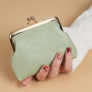 Vintage light green PU leather coin purse with golden metal clasp shown held by hand