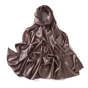 Detailed view of bronze satin silk scarf showing soft folds and lustrous fabric texture