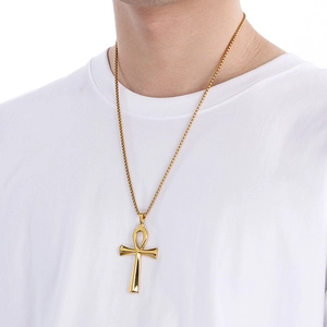Model wearing gold Egyptian Ankh cross pendant with box chain over white shirt