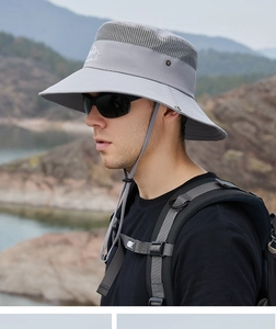 Macro detail of breathable mesh and mountain logo on a gray outdoor sun protection hat