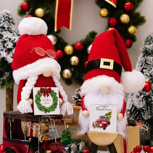 Detail of knitted Christmas gnomes with wooden signs and plush holiday decorations