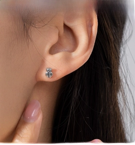 Close-up of vintage S925 silver owl stud earring showing fine feather textures on ear