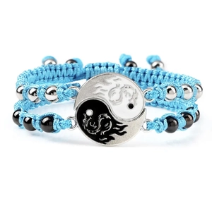 Detail of blue braided bracelet featuring Yin Yang pendant with dragon and phoenix motifs