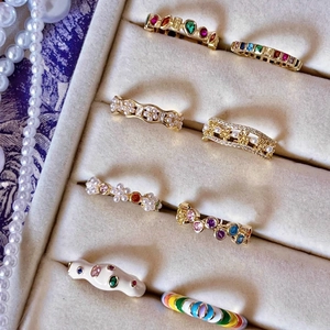 Rainbow enamel and pearl open rings set in gold finish for a trendy layered look