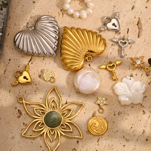 18K gold plated stainless steel charms including heart wings and key pendants on stone