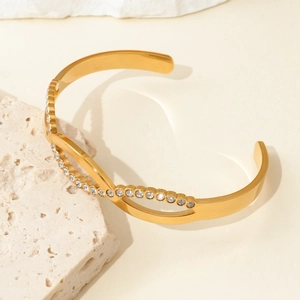 Close-up of gold titanium steel braided open cuff bracelet with sparkling zircon stones