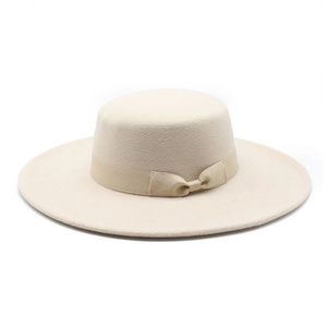 Close-up of beige wool boater hat featuring a flat top and elegant bow ribbon detail