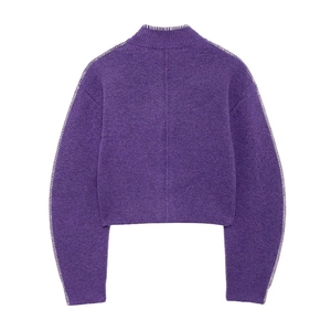 Dettaglio del maglione viola lavorato a maglia con cuciture bianche e trama soffice