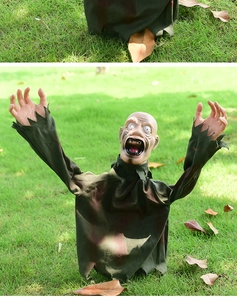 Detailed view of scary zombie lawn decoration with tattered green clothes and realistic plastic head
