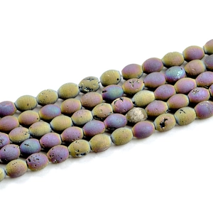Macro view of purple and gold druzy agate drum beads with natural geode textures