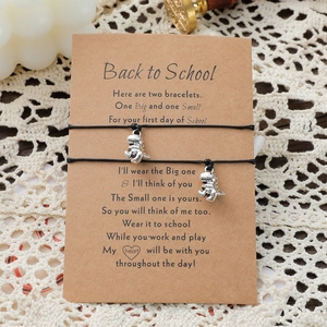 Braccialetti regolabili con dinosauro e ciondoli in argento su carta Back to School