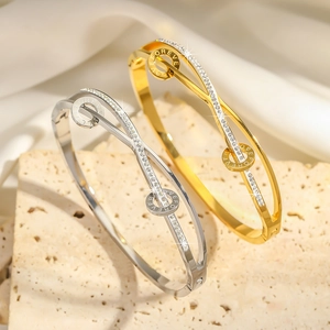 Makroaufnahme von Gold- und Silberarmreifen mit Mikropave-Steinen und FOREVER-Gravur