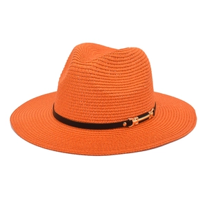 Detail of orange woven straw Fedora hat with black leather band and gold metal buckle