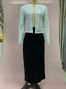 Detail of silver sequined cropped jacket and black maxi skirt on a mannequin