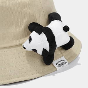 Detailed close-up of a beige canvas bucket hat featuring a 3D plush panda ornament