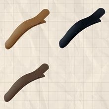 Close-up showing three vintage matte acrylic hair clips in tan, black and brown
