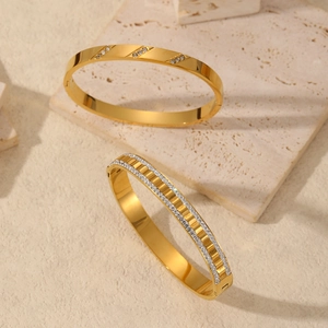 Elegant 18K gold-plated stainless steel bangles with sparkling crystals on textured stone