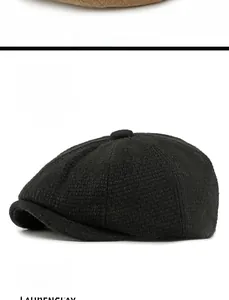 Detail view of the black wool blend newsboy cap showing its knitted texture and top button