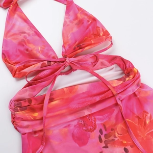 Détail de la robe dos nu à imprimé floral rose avec découpes et lacets sur fond blanc
