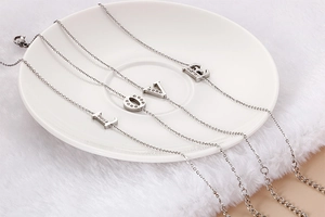 Detail of four silver titanium bracelets featuring LOVE letter charms with sparkly zircon stones