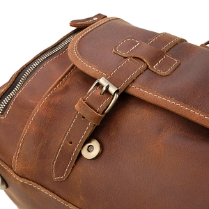 Detail of vintage crazy horse leather bag with retro buckle and white stitching