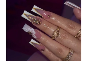 Detailed view of square press-on nails with 3D white flowers and gold glitter V-lines