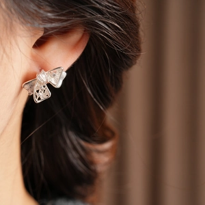 Gros plan de boucles d'oreilles nœud en zircon avec filigrane sur un modèle chic