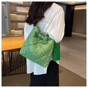 Borsa tote trapuntata verde con tracolla a catena presentata in un contesto lifestyle