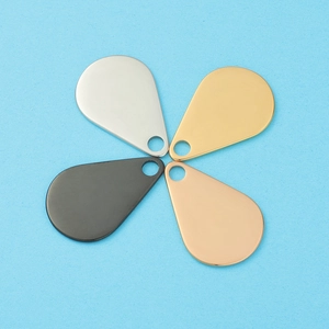 Detailed view of teardrop metal pendants in silver, gold, rose gold and black finish