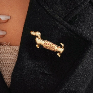 Detailed view of dachshund dog brooch with brown silk thread on a black coat