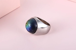 Macro shot of silver stainless steel ring featuring a colorful cosmic glass dome centerpiece