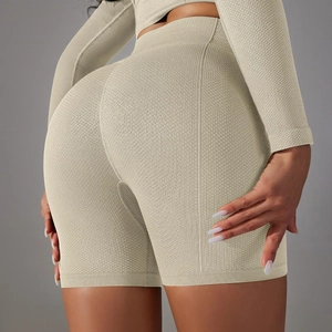 Dettaglio del tessuto a nido d'ape beige e cucitura modellante sui pantaloncini da yoga