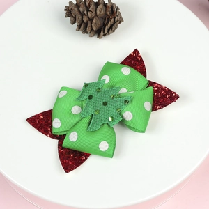 Christmas bow hair clip with glitter green tree and red sequins on white plate