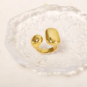 Macro shot of minimalist gold open ring with polished liquid mirror finish on glass surface
