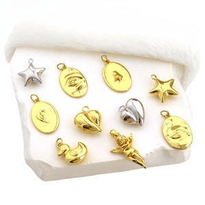 Detailed view of assorted gold and silver metal charms with faces and heart shapes