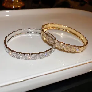 Luxe quilted grid bangle with pavé zircons in gold and silver finish on white ceramic tray
