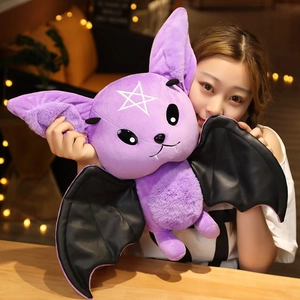 Plush purple devil bat toy with black wings and white star held by a model