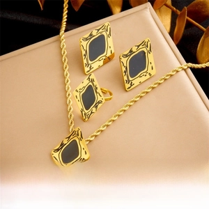 Detail of gold-plated geometric jewelry set with black enamel diamond-shaped pendants