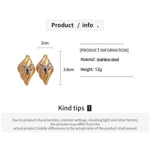 Détail de boucles d'oreilles pendantes de 3,8 cm avec texture ondulée et nœud argenté